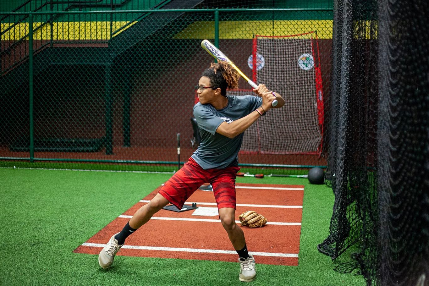 A teen boy swinging a baseball bat